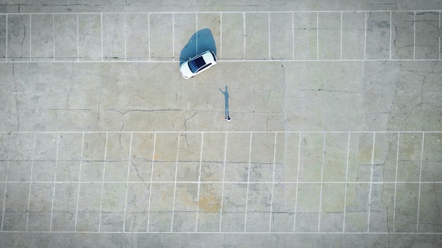 empty car lot with one car and person standing