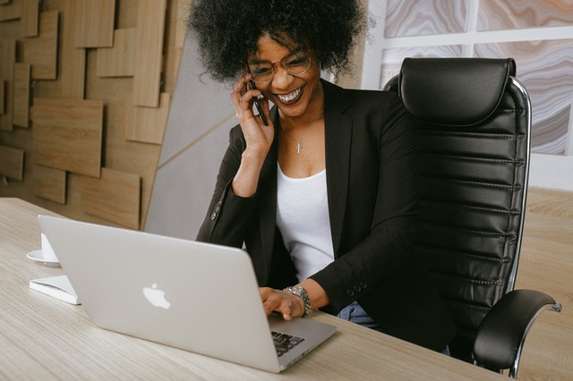 happy businesswoman on phone with laptop
