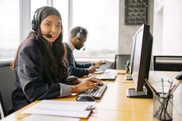 smiling woman with headset at computer