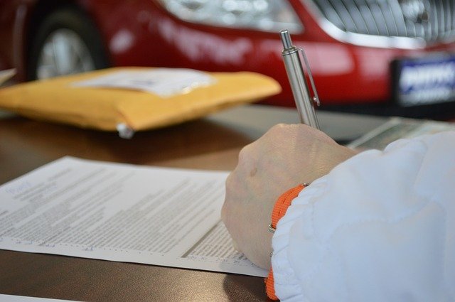 paperwork signing car in background